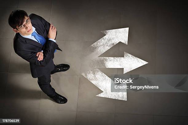 Man Wearing A Suit With Arms Folded And White Arrows Stock Photo - Download Image Now