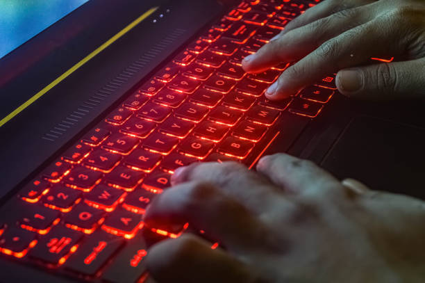 istock hands typing on a gaming laptop keyboard that glows red 1787068681