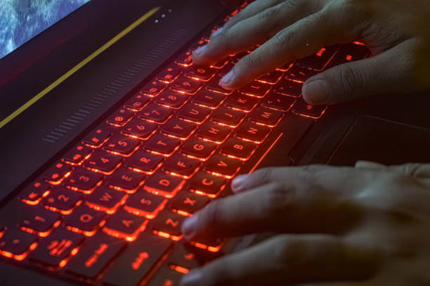 istock hands typing on a gaming laptop keyboard that glows red 1787069187