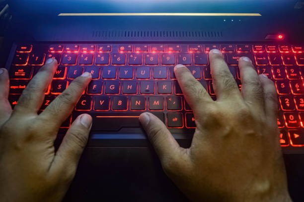 istock hands typing on a gaming laptop keyboard that glows red 1787069706