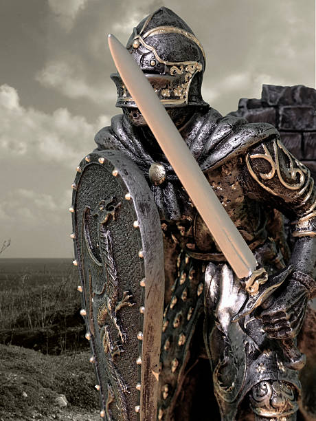 A knight dressed in ornate armor with sword and shield stock photo