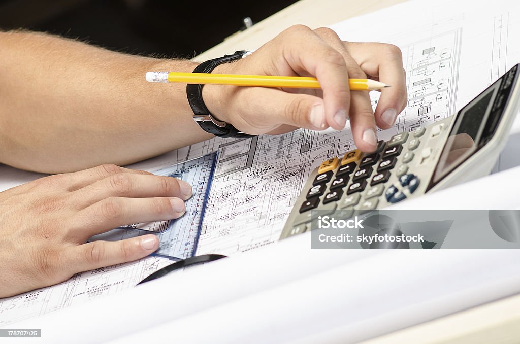 Hombre trabajando con una calculadora y cuadrada dibujo - Foto de stock de Arquitecto libre de derechos