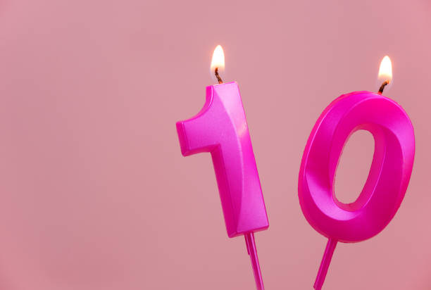 istock Pink birthday candles burning on pink, number 10, room for text. 1787076885