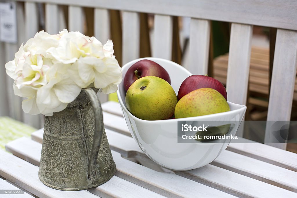 decoration of summer garden table decoration of summer garden table. Flowers in vase and fresh apples Arrangement Stock Photo