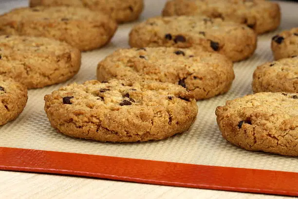 Fresh baked Stack of warm chocolate  chips cookies on baking silicone sheet  shallow DOF