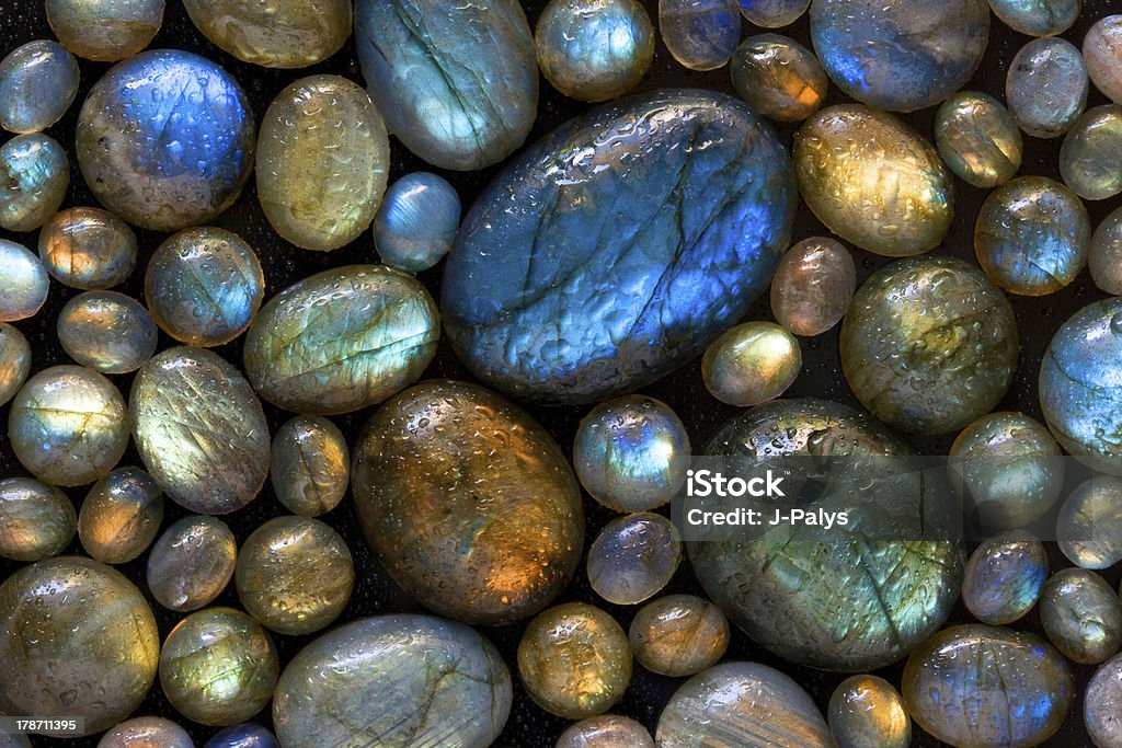 Natural background of labradorite gemstones. Beautiful natural texture: closeup picture of colorful wet labradorite gems. Aura Stock Photo