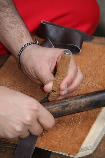 istock expert craftsman working leather with awl and hammer 178715367