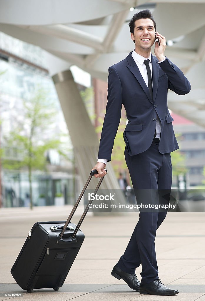 Jovem empresário com telefone e sacola de viagem - Foto de stock de A caminho royalty-free