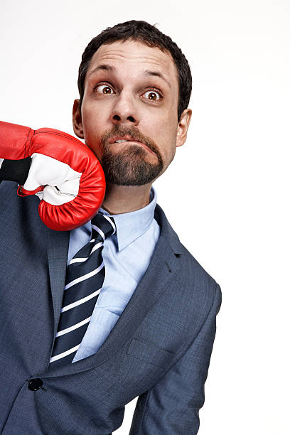 istock Young business man struck by hand in boxing glove 178716605