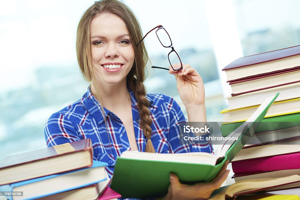 Successful student Portrait of diligent student looking at camera with open book in hands Adult Stock Photo