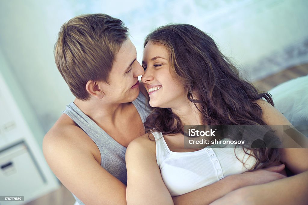 Sweet embrace Handsome guy embracing his girlfriend at home Adult Stock Photo