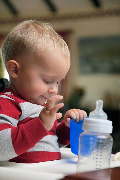 istock baby boy playing with bottle and mug indoor 178717957