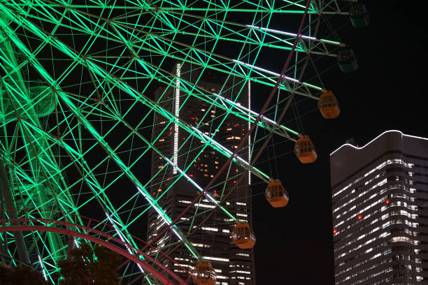 Green illumination of the Ferris wheel in Yokohama City, Japan and night view of skyscrapers