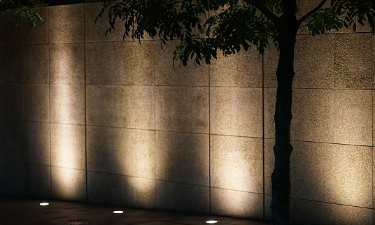Spotlights illuminating the exterior walls of buildings at night