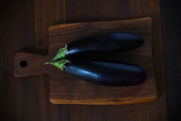 Photo of Eggplants or aubergine vegetable on a chopping board