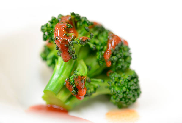 Broccoli with red sauce stock photo