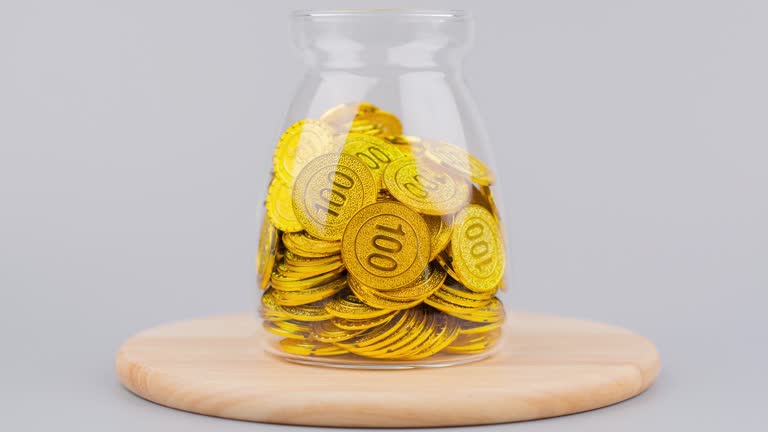 Gold coins in a glass jar. Gold savings. Gold market. Stop motion gold.