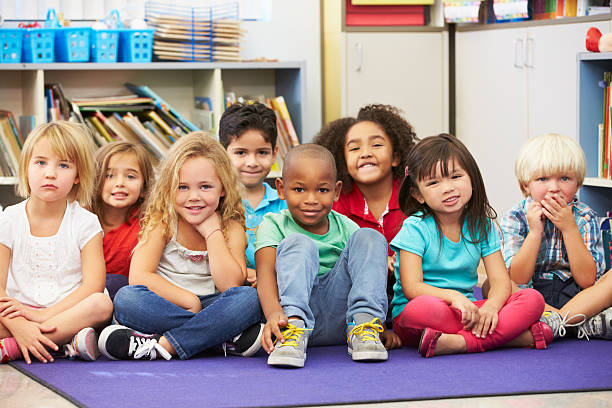 istock Elementary pupils sitting on the floor in a classroom 178721102