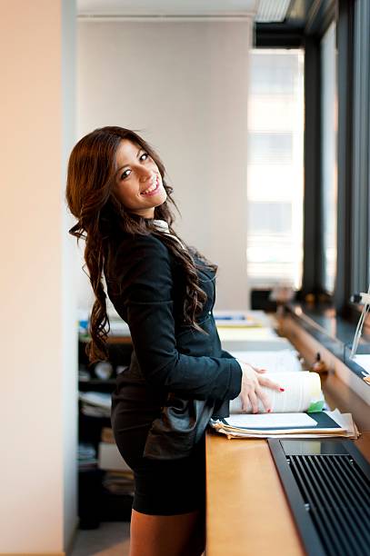 istock young business woman posing on office background 178722433