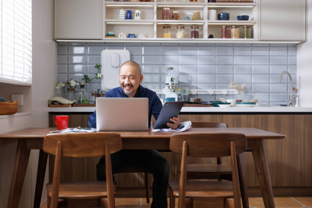 istock Middle aged men work with laptops at home 1787229274