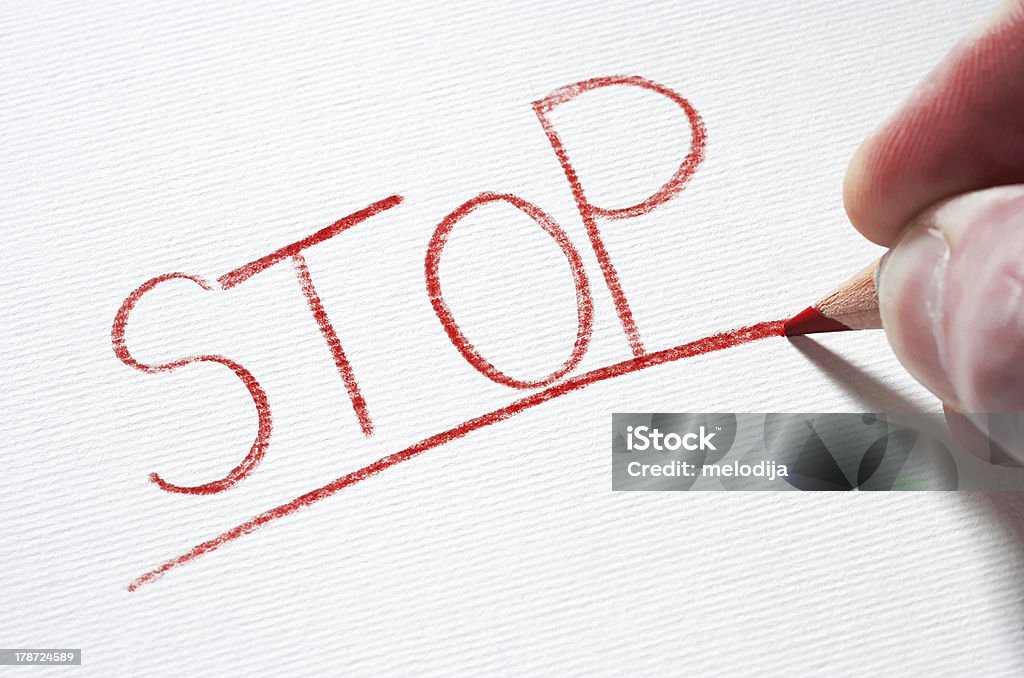 Stop A red pencil is smash on a piece of paper after writing the word 'STOP'. Abstract Stock Photo