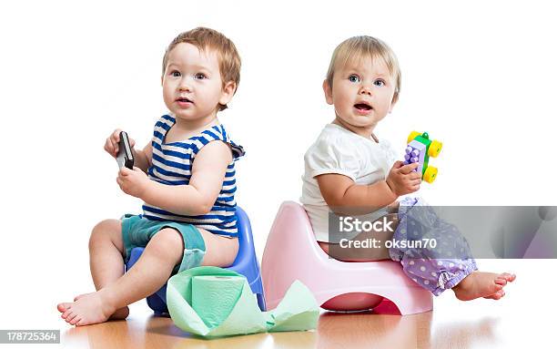 Babies Toddlers Sitting On Chamber Pot And Playing With Toys Stock Photo - Download Image Now