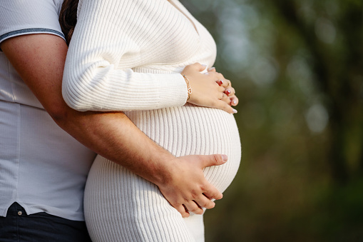 Pregnant young woman with her husband in nature