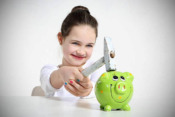 Little girl breaking piggy bank Little girl breaking piggy bank isolated on white girl with a hammer stock pictures, royalty-free photos & images