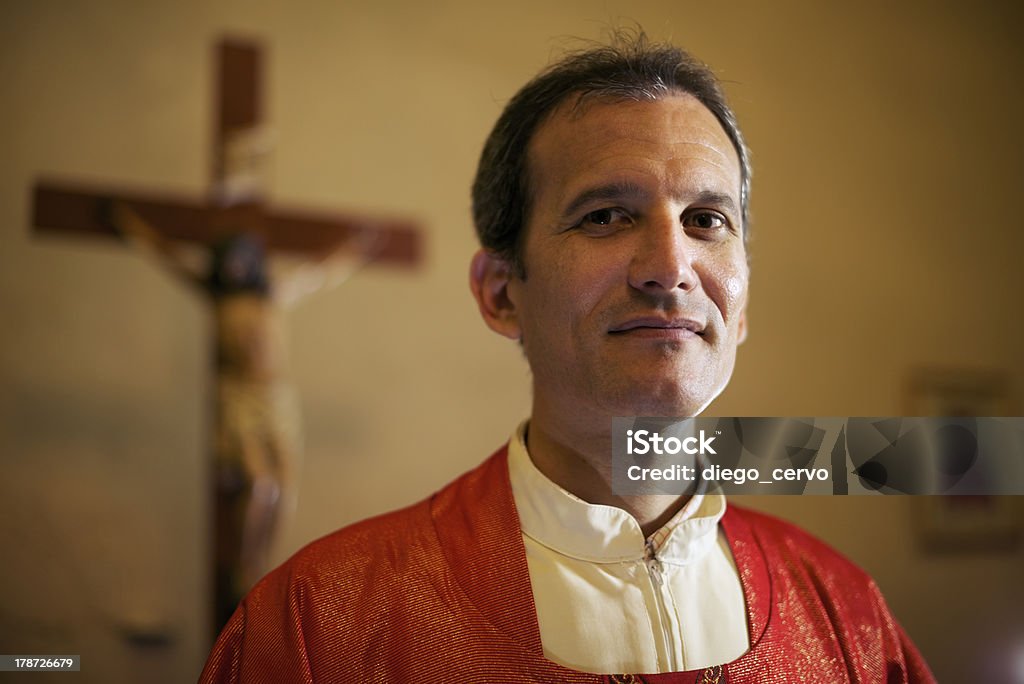 Ritratto di felice sacerdote cattolico sorridendo alla telecamera nella chiesa - Foto stock royalty-free di Prete