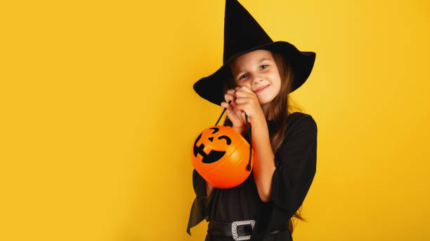 istock Happy Halloween! Cute little witch on yellow background. Copy space 1787267117