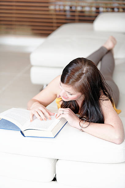 istock Woman lying on sofa with a book 178727135