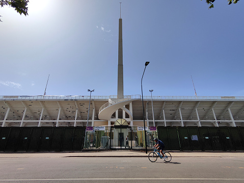 Man cycling at the Stadio Artemio Franchi, with the tower of Maratona. The stadium is built entirely of reinforced concrete. It is currently the home of ACF Fiorentina.\nFlorence, Italy