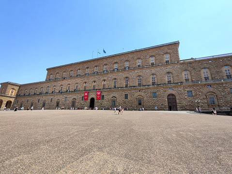 Tourist walking by the majestic historical Palazzo Pitti, Florence, Tuscany