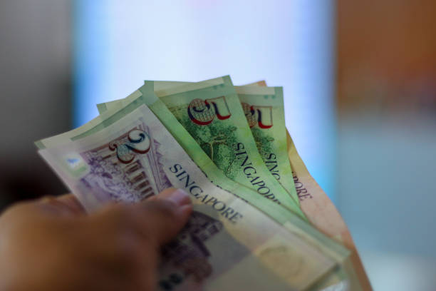 istock Hand holding Singapore dollar banknotes. 1787301036