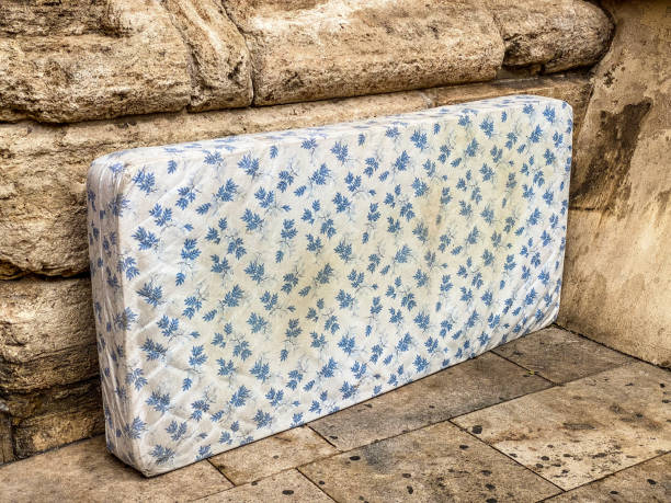 istock Abandoned mattress lying over stone wall 1787303768