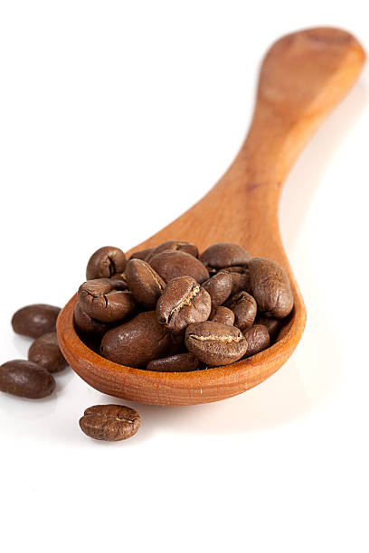 istock wooden spoon with coffee beans isolated over white 178730389