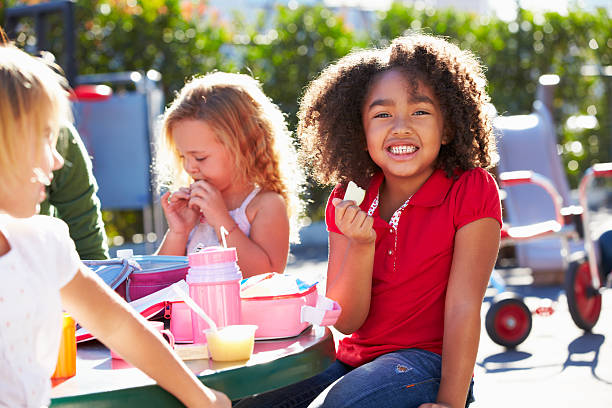 podstawowej uczniowie siedzący przy stole jeść lunch - school lunch lunch child healthy eating zdjęcia i obrazy z banku zdjęć