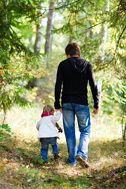 istock Father and daughter walking in park 178730501