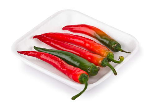 Hot red chilli peppers on market tray isolated on white background (with clipping path)