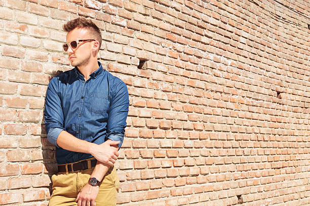 casual man stands next to wall