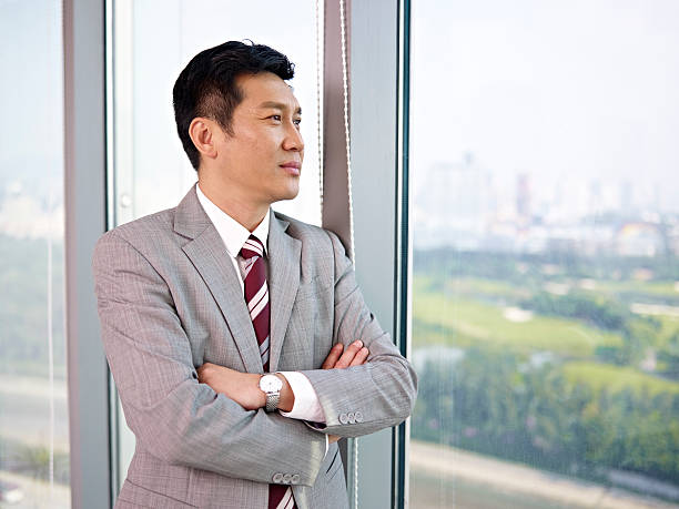 アジアのビジネスマン - businessman looking through window ストックフォトと画像