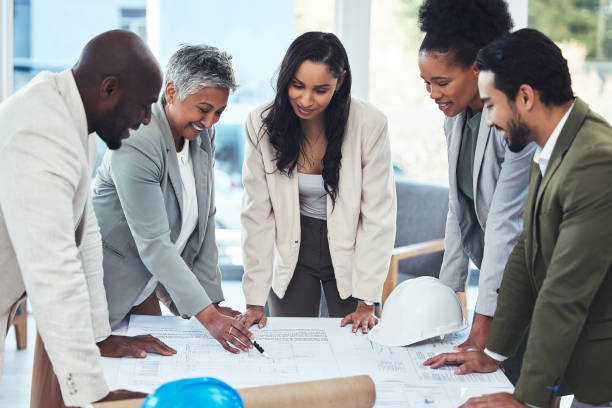 istock Architecture, engineering and people in meeting with blueprint for planning, building and property development. Teamwork, construction and contractors with illustration, drawing design and floor plan 1787322479