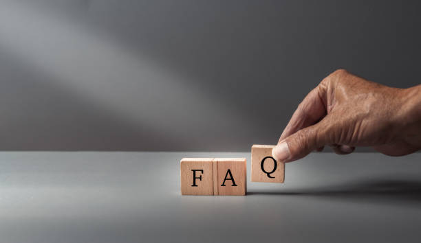 istock hand posing FAQ, frequently asked questions, text FAQ, written on wooden cubes on  a grey blue background ,concept of customer service or assistance . 1787340192