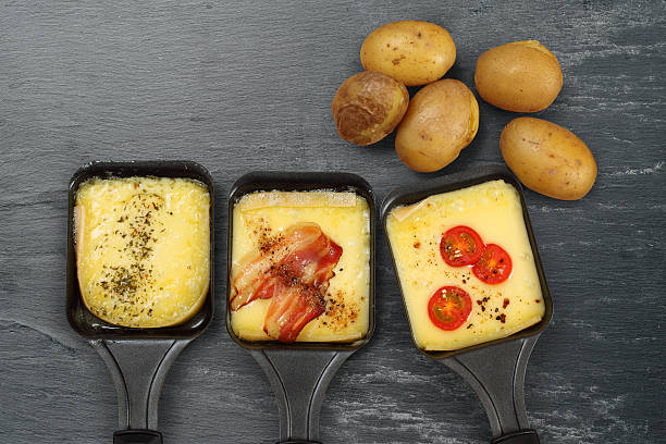 раклетт подносы и картофель - raclette cheese стоковые фото и изображения