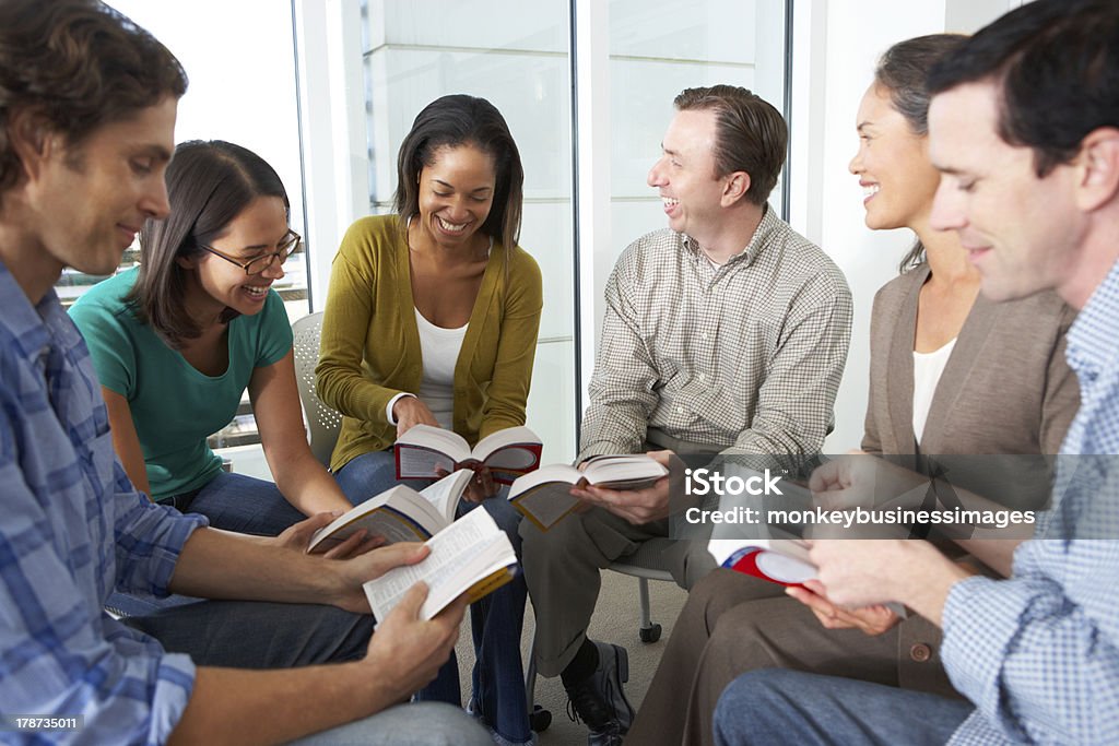 Bible group reading together in a close circle Bible Group Reading Together Having A Conversation With Each Other Bible Stock Photo