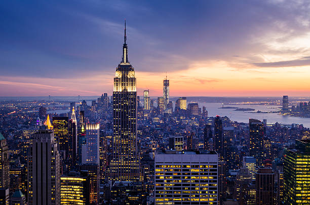 Dramatic sunset view highlighting the Empire State Building New York City with skyscrapers at sunset empire state building photos stock pictures, royalty-free photos & images
