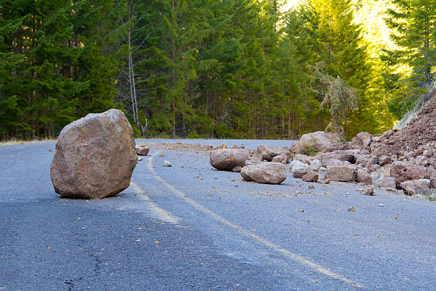 Closeup of the landslide of a blocked road This national forest road is blocked by a land slide of rock and debris to where it is a hazard for drivers in cars. boulder rock stock pictures, royalty-free photos & images