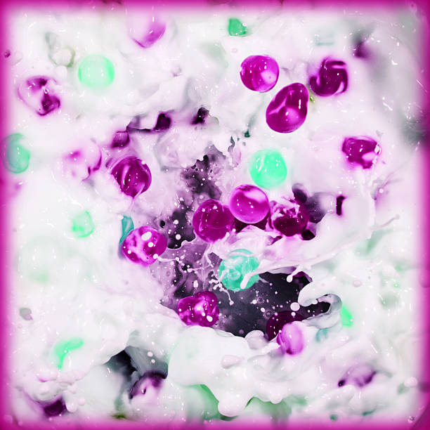 Pink and green balls splashing into milk