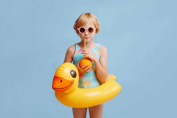 istock Child with inflatable duck ring on blue background with copy space. 1787385872