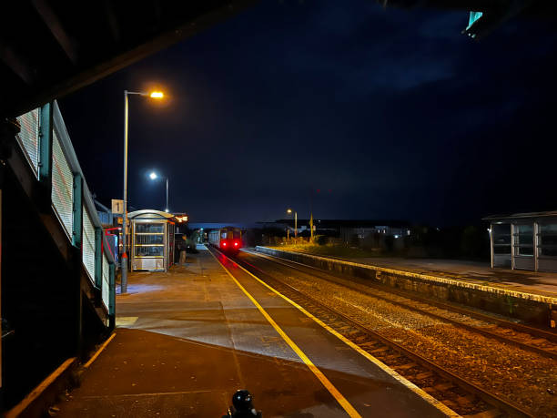 Pociąg odjeżdżający z dworca kolejowego w nocy – zdjęcie